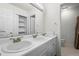 Bathroom featuring a double sink vanity and a linen closet, blending convenience and functionality at 46531 Sundance Trl, Parker, CO 80138