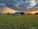 Beautiful home exterior at sunset with open field and cloudy sky, conveying peaceful rural living at 46531 Sundance Trl, Parker, CO 80138