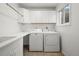 Bright laundry room with modern appliances and ample counter space for folding and sorting laundry at 46531 Sundance Trl, Parker, CO 80138