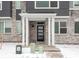 Inviting front entrance with modern door, white columns, and stone facade with snow-covered yard at 22340 E 8Th Ave, Aurora, CO 80018