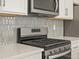 Detailed view of stainless steel gas range and custom tile backsplash at 22340 E 8Th Ave, Aurora, CO 80018