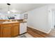 Open kitchen with white dishwasher, sink and wooden cabinets; view to living space at 5425 County Road 32 # 27, Mead, CO 80504