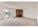 Spacious living room with a cozy brick fireplace and sliding doors to balcony at 3436 S Locust St # D, Denver, CO 80222