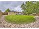 Extensive backyard featuring green lawn, patio set, mature trees and a surrounding decorative rock perimeter at 6046 Vrain St, Arvada, CO 80003