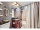 Bathroom featuring granite vanity, decorative mirror, shower with curtain, and tiled walls at 6046 Vrain St, Arvada, CO 80003