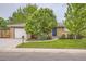 Charming brick home with a well-manicured lawn, a blue front door, and an attached garage at 6046 Vrain St, Arvada, CO 80003