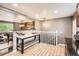 Open kitchen with a center island, stainless appliances, and hardwood style flooring at 6046 Vrain St, Arvada, CO 80003