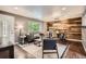 Open-concept living room with wood accent wall, hardwood floors, and modern furniture at 6046 Vrain St, Arvada, CO 80003