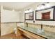 Bathroom featuring double sinks with glass vessel bowls and stone countertop at 7895 W 67Th Ave, Arvada, CO 80004