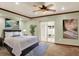Bright bedroom features a ceiling fan, neutral walls, and sliding glass doors to the outside at 7895 W 67Th Ave, Arvada, CO 80004