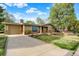 Charming single-story home with a well-manicured lawn, stone accents, and a spacious driveway at 7895 W 67Th Ave, Arvada, CO 80004