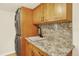 Practical laundry room with stacked washer/dryer, granite countertop, and ample cabinet space at 7895 W 67Th Ave, Arvada, CO 80004