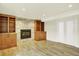 Spacious living area featuring a fireplace with stone surround, built-in shelving, and wood flooring at 7895 W 67Th Ave, Arvada, CO 80004