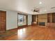 Spacious living room features hardwood floors, a stone fireplace, and built-in shelving at 7895 W 67Th Ave, Arvada, CO 80004