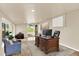 Bright office featuring a large wooden desk, comfortable seating, and sliding glass doors to the outdoors at 7895 W 67Th Ave, Arvada, CO 80004