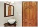 Powder room features vessel sink on a cabinet vanity and decorative mirror at 7895 W 67Th Ave, Arvada, CO 80004