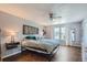 Cozy primary bedroom with hardwood floors, ceiling fan, large window, and neutral decor at 10440 W 83Rd Ave, Arvada, CO 80005