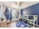 Whimsical bedroom featuring a loft bed, blue accent wall, and space-themed decor at 10440 W 83Rd Ave, Arvada, CO 80005