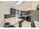 Modern kitchen with gray cabinets, marble countertops, mosaic backsplash, and stainless steel appliances at 10440 W 83Rd Ave, Arvada, CO 80005