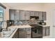Contemporary kitchen featuring gray cabinets, mosaic backsplash, marble counters, and stainless steel appliances at 10440 W 83Rd Ave, Arvada, CO 80005