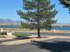 Scenic lake view featuring mature trees and distant mountains on a clear day at 10440 W 83Rd Ave, Arvada, CO 80005