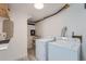 Functional laundry room with washer, dryer, and built-in shelving at 10440 W 83Rd Ave, Arvada, CO 80005