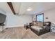 Cozy carpeted living room featuring a sectional sofa and wooden ceiling beams at 10440 W 83Rd Ave, Arvada, CO 80005