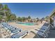 Relaxing community pool with lounge chairs and mature trees offering a tranquil setting on a sunny day at 10440 W 83Rd Ave, Arvada, CO 80005