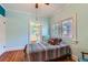 Bright bedroom with a colorful quilt, wood floors, and two windows at 2541 Bellaire St, Denver, CO 80207