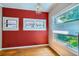 Bedroom featuring a red accent wall, hardwood floors, and a charming chandelier at 2541 Bellaire St, Denver, CO 80207
