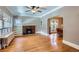 Open living room with a fireplace, hardwood floors, built-in shelves, and a dining area beyond at 2541 Bellaire St, Denver, CO 80207