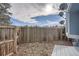 Backyard with wood fence and leaves with a glimpse of a blue sky at 7904 Chase Cir # 147, Arvada, CO 80003