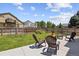Well-maintained backyard featuring lush green grass, mature trees, a patio area, and a firepit at 16581 Buckthorn Ln, Parker, CO 80134