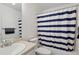 This bathroom is equipped with a shower/tub combo featuring a blue and white striped shower curtain at 16581 Buckthorn Ln, Parker, CO 80134