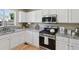 Bright kitchen featuring granite counters, white cabinets, and stainless steel appliances at 16581 Buckthorn Ln, Parker, CO 80134