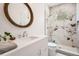 Modern bathroom with a wooden-framed mirror, white vanity, and a glass-enclosed shower with marble tiling at 6102 S Aberdeen St, Littleton, CO 80120