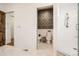 Modern bathroom with a glass-enclosed shower and a separate toilet room featuring decorative wallpaper at 6102 S Aberdeen St, Littleton, CO 80120