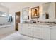 Elegant bathroom with dual vanity, marble countertops, soaking tub, and wood door at 6102 S Aberdeen St, Littleton, CO 80120