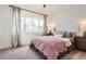 Bright bedroom featuring neutral walls, soft carpet, and a large window dressed with sheer curtains at 6102 S Aberdeen St, Littleton, CO 80120