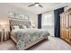 Bedroom featuring a plush bed with a decorative headboard, a side table, and light-filled windows at 6102 S Aberdeen St, Littleton, CO 80120