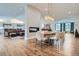 Open-concept dining area with hardwood floors, a modern fireplace, and seamless flow to the kitchen and living room at 6102 S Aberdeen St, Littleton, CO 80120
