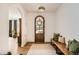 Welcoming foyer with arched entryway, hardwood floors, decorative rug, and an arched wood front door at 6102 S Aberdeen St, Littleton, CO 80120