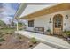 Inviting front porch with a charming bench, stylish decor, and an arched wooden door for a warm welcome at 6102 S Aberdeen St, Littleton, CO 80120