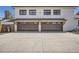 Modern two-car garage featuring dark wood doors, complemented by a large concrete driveway and black framed windows above at 6102 S Aberdeen St, Littleton, CO 80120