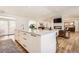 Bright, open kitchen featuring a large island with white cabinets and marble countertop, with view to the living room at 6102 S Aberdeen St, Littleton, CO 80120