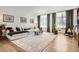 Bright living room featuring hardwood floors, large windows with curtains, and comfortable seating for relaxation and entertainment at 6102 S Aberdeen St, Littleton, CO 80120