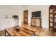 Open-plan entertainment room features a TV, kitchenette, and stylish hardwood floors at 6102 S Aberdeen St, Littleton, CO 80120