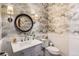 Charming powder room with floral wallpaper, elegant lighting, and a classic pedestal sink offering style and convenience at 6102 S Aberdeen St, Littleton, CO 80120