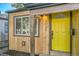 Welcoming front entrance with a bright yellow door and natural wood siding at 1765 Kingston St, Aurora, CO 80010