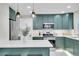 Stylish kitchen featuring trendy green cabinets, stainless appliances and quartz countertops at 1765 Kingston St, Aurora, CO 80010